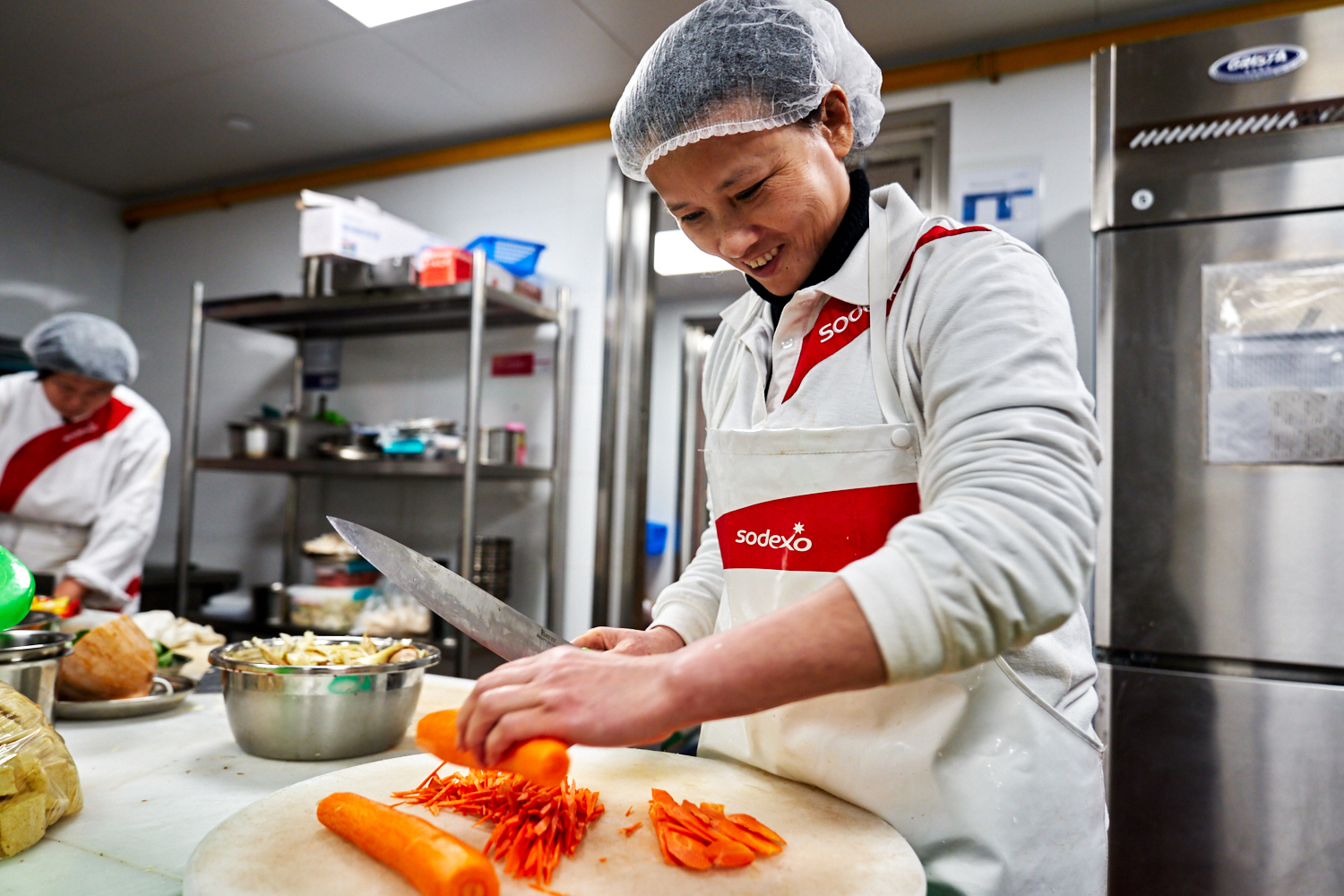 Sodexo chef cutting tomatoes in a kitchen