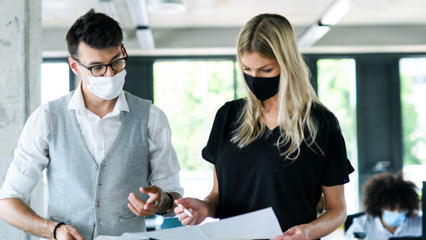 Man and woman in masks reviewing documents
